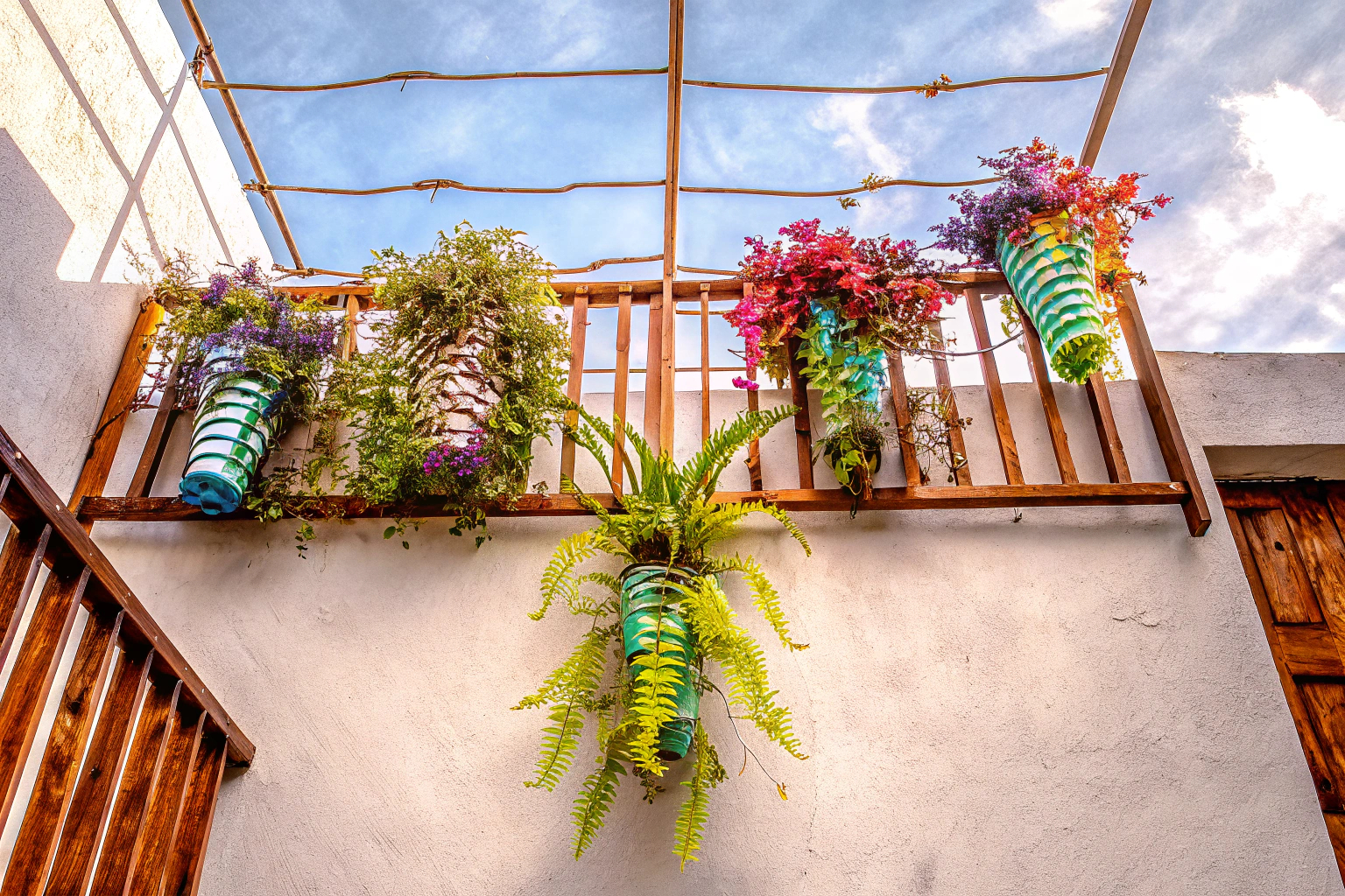 Wandvasen mit Pflanzen auf einem Balkon